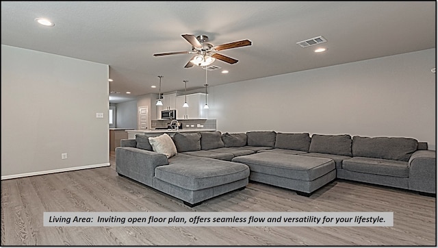 living room with light hardwood / wood-style flooring and ceiling fan