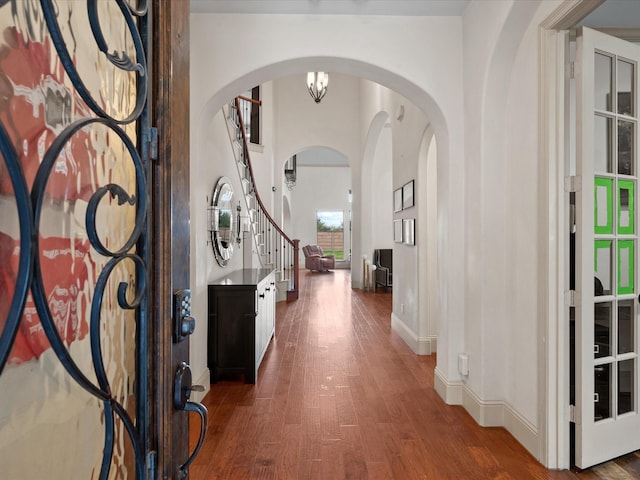 entrance foyer with dark hardwood / wood-style floors and an inviting chandelier