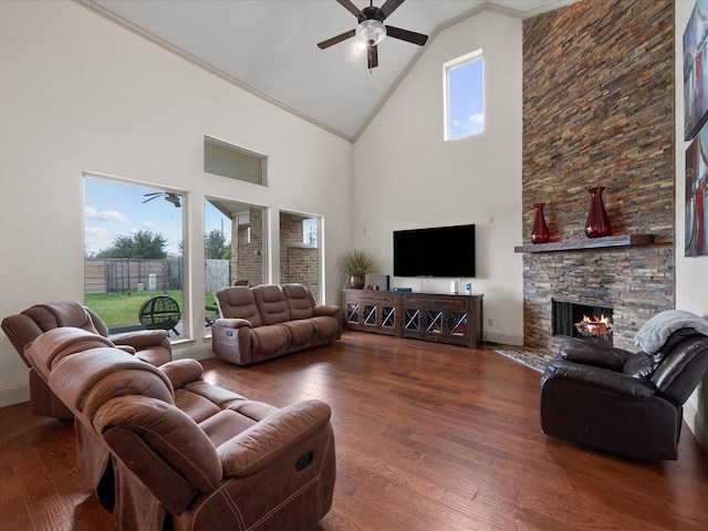 living room featuring a stone fireplace, plenty of natural light, high vaulted ceiling, and hardwood / wood-style floors