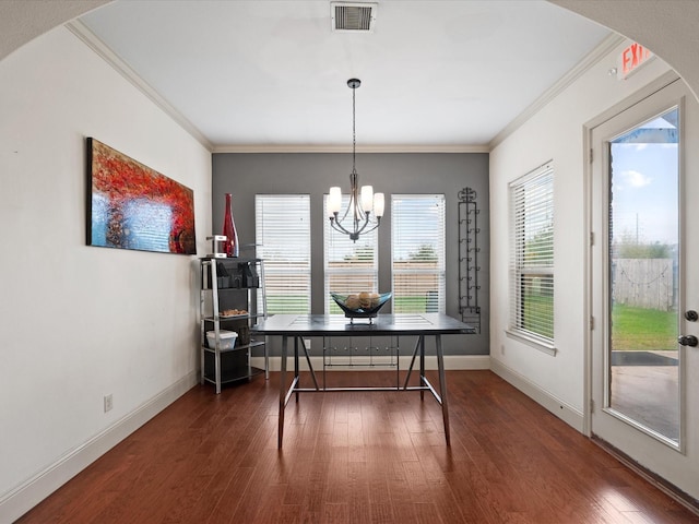 dining area with ornamental molding, dark hardwood / wood-style floors, plenty of natural light, and a notable chandelier