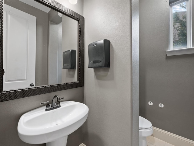 bathroom featuring tile patterned flooring, toilet, and sink