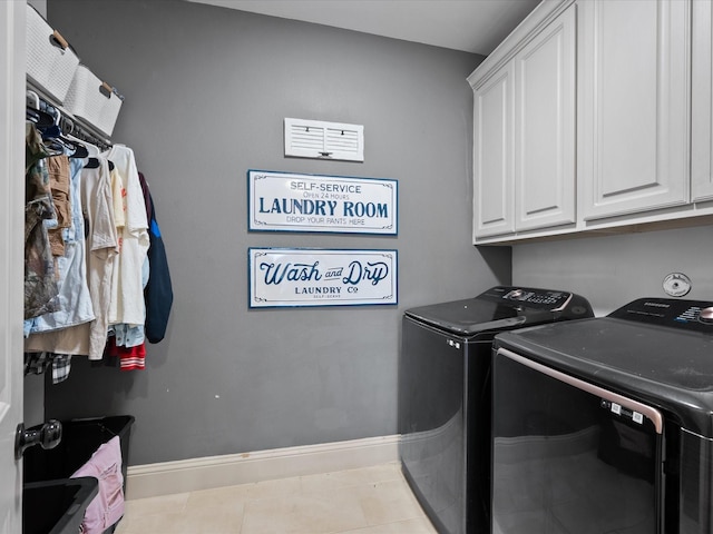 laundry area with cabinets, washer and clothes dryer, and light tile patterned floors