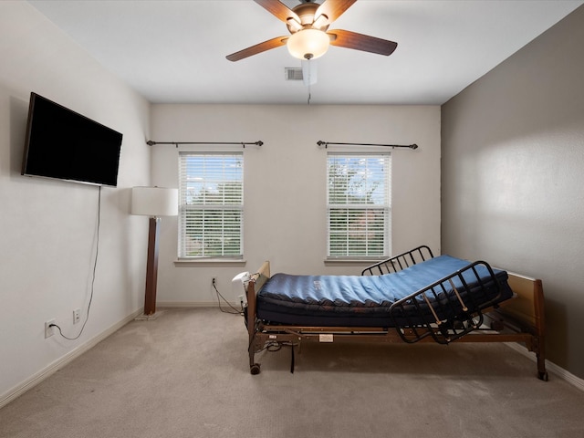 carpeted bedroom featuring ceiling fan and multiple windows