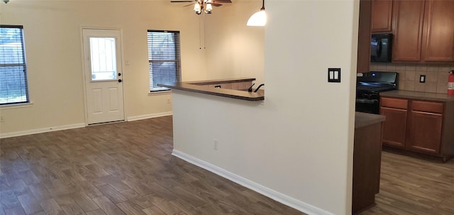 kitchen featuring ceiling fan, dark hardwood / wood-style floors, backsplash, decorative light fixtures, and black appliances