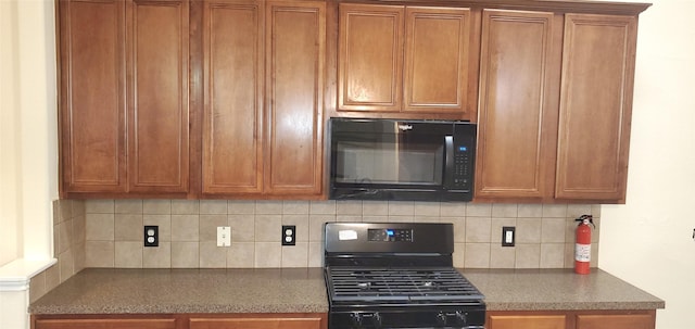 kitchen with black appliances and tasteful backsplash