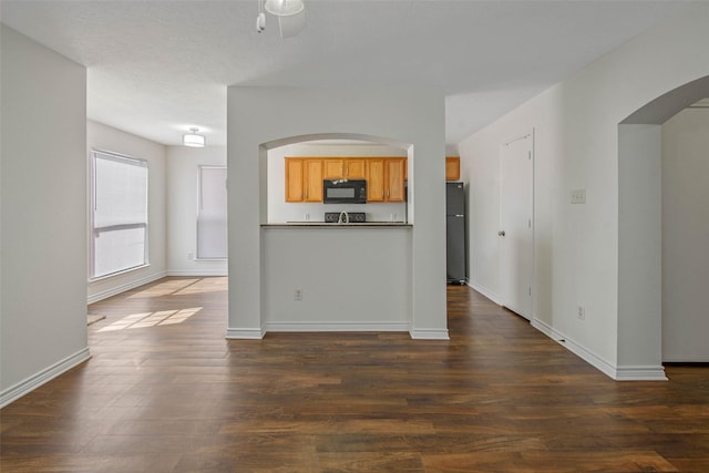 unfurnished living room with dark hardwood / wood-style flooring