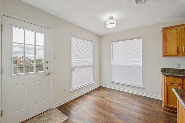 doorway featuring dark hardwood / wood-style flooring and a textured ceiling