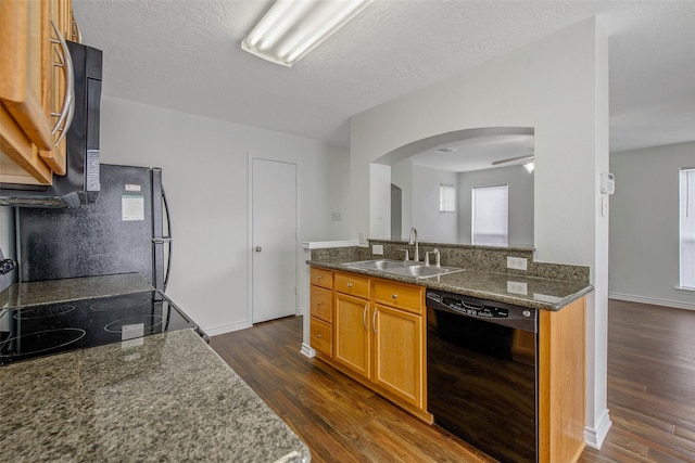 kitchen featuring black appliances, dark hardwood / wood-style floors, sink, and a textured ceiling