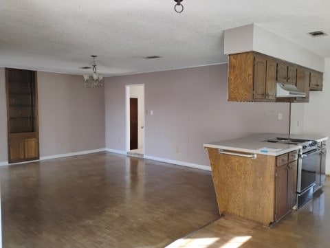 kitchen with stainless steel range, a textured ceiling, dark hardwood / wood-style flooring, and an inviting chandelier