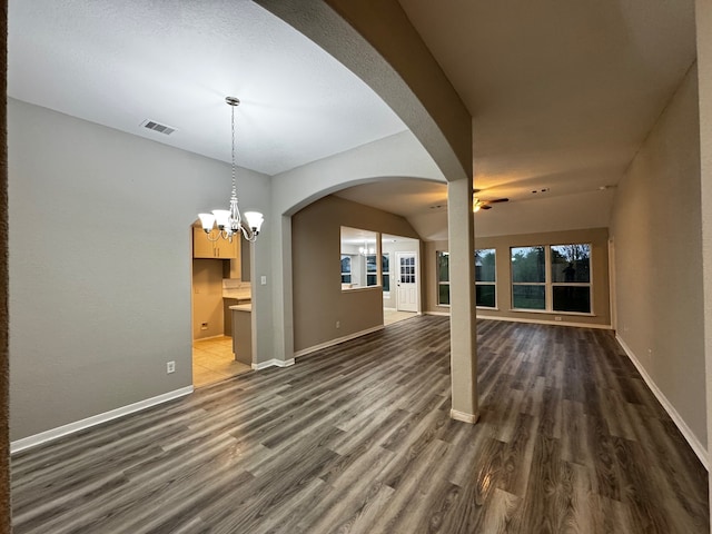 interior space with ceiling fan with notable chandelier and dark wood-type flooring