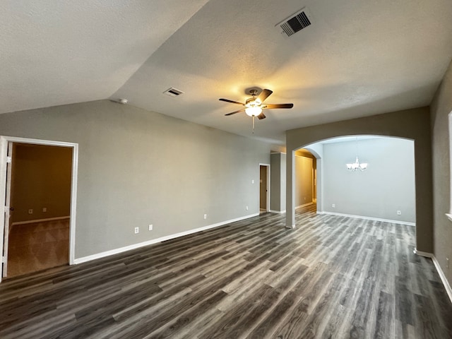 spare room with a textured ceiling, ceiling fan with notable chandelier, dark wood-type flooring, and vaulted ceiling