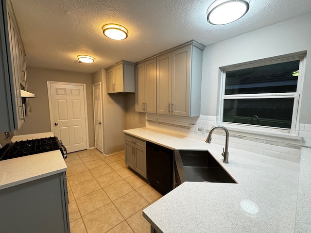 kitchen with a textured ceiling, gray cabinets, sink, and black dishwasher