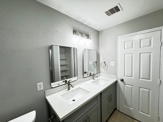 bathroom featuring tile patterned flooring, vanity, and a textured ceiling