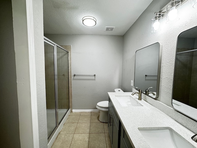 bathroom with tile patterned floors, an enclosed shower, a textured ceiling, toilet, and vanity