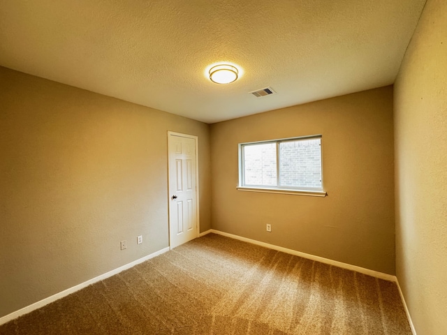 spare room with carpet and a textured ceiling