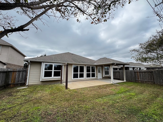 rear view of property with a lawn and a patio