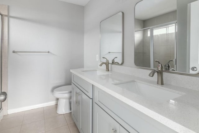 bathroom featuring vanity, toilet, a shower with shower door, and tile patterned flooring