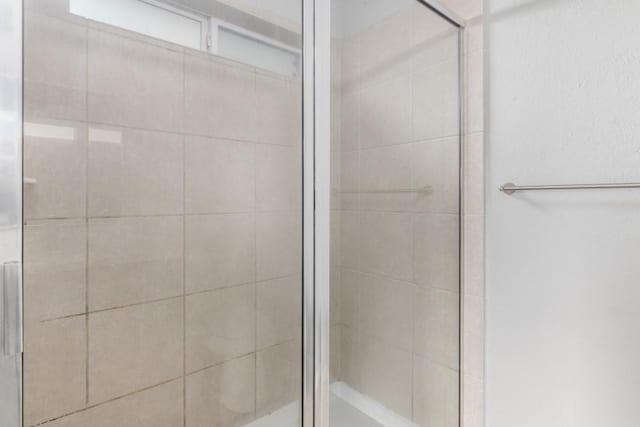 bathroom featuring a shower with door