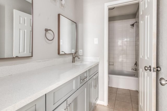 bathroom with tile patterned flooring, vanity, and tiled shower / bath