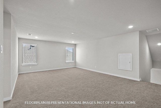 empty room with carpet flooring and a textured ceiling