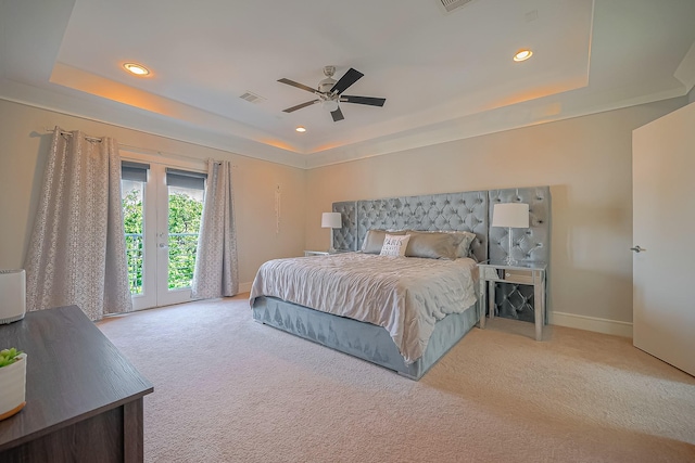 bedroom with ceiling fan, light carpet, access to outside, and a tray ceiling