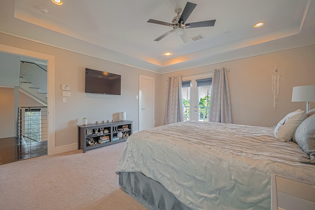 carpeted bedroom featuring a tray ceiling, access to exterior, ceiling fan, and french doors