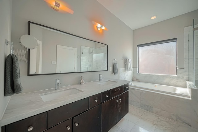 bathroom with vanity and shower with separate bathtub