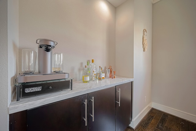 bar featuring dark brown cabinets and dark wood-type flooring