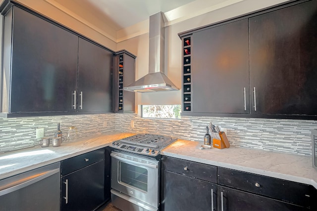 kitchen with wall chimney exhaust hood, light stone countertops, decorative backsplash, and appliances with stainless steel finishes