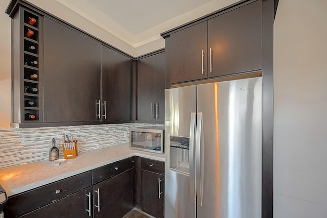 kitchen featuring backsplash, dark brown cabinetry, and stainless steel appliances