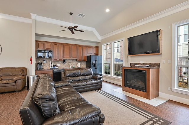 living room with hardwood / wood-style flooring, crown molding, and a wealth of natural light