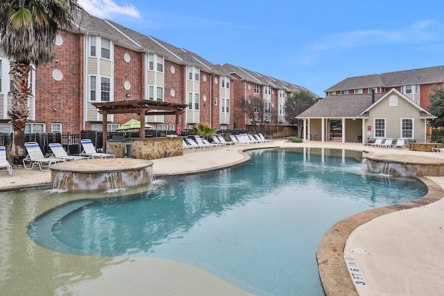 view of swimming pool with a pergola, pool water feature, a bar, and a patio