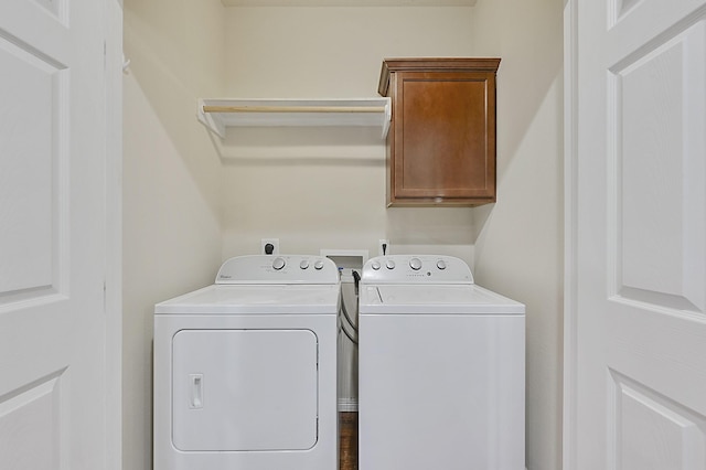 laundry area with washer and dryer, wood-type flooring, and cabinets