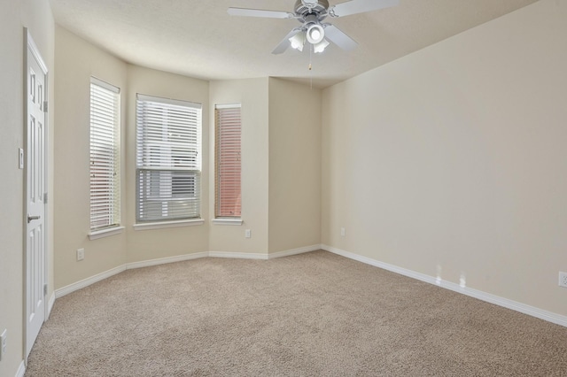 spare room featuring light carpet and ceiling fan