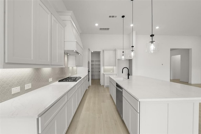 kitchen featuring sink, hanging light fixtures, a spacious island, appliances with stainless steel finishes, and light wood-type flooring