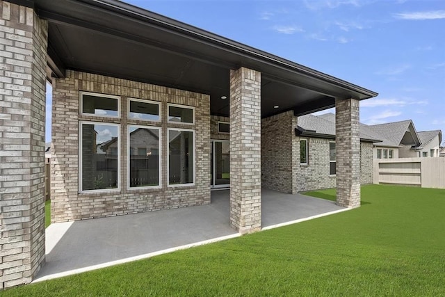 back of property with a lawn and a patio area