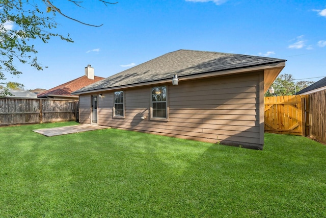 back of house featuring a patio area and a lawn