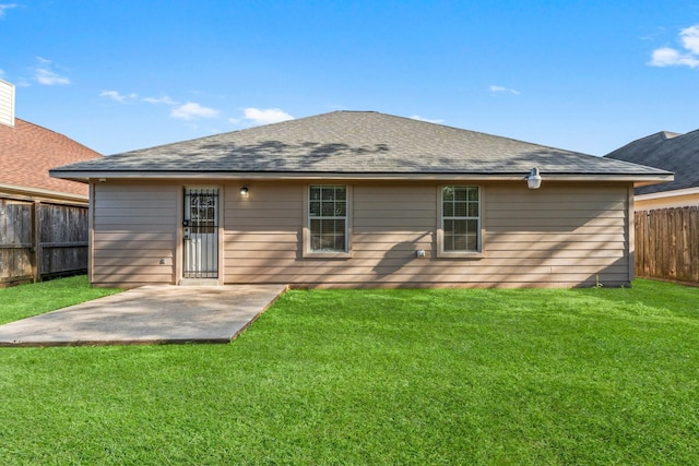 back of house with a lawn and a patio