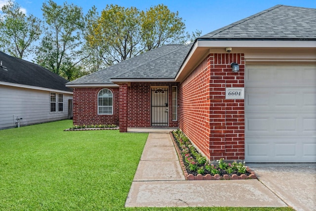 doorway to property with a garage and a yard