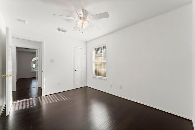 empty room with dark hardwood / wood-style floors and ceiling fan