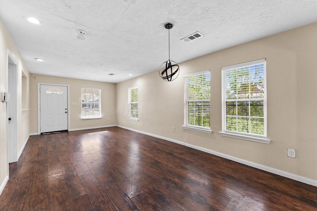 foyer entrance featuring a textured ceiling and dark hardwood / wood-style flooring