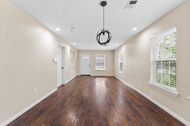 interior space with a textured ceiling and dark wood-type flooring