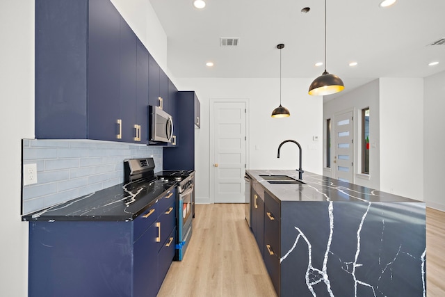 kitchen featuring blue cabinetry, sink, stainless steel appliances, light hardwood / wood-style flooring, and decorative light fixtures