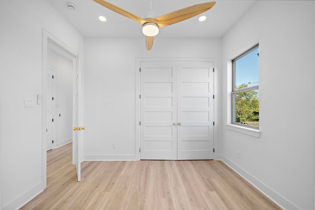 unfurnished bedroom with ceiling fan, light wood-type flooring, and a closet