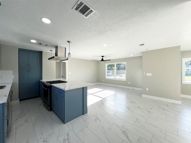 kitchen with light stone counters, gas range, ventilation hood, ceiling fan, and hanging light fixtures