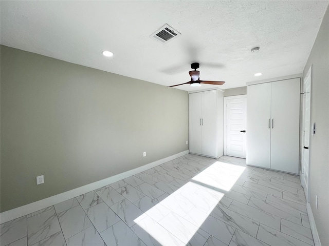 unfurnished bedroom featuring ceiling fan and a textured ceiling