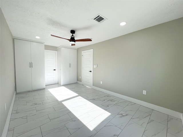 unfurnished bedroom with a textured ceiling and ceiling fan