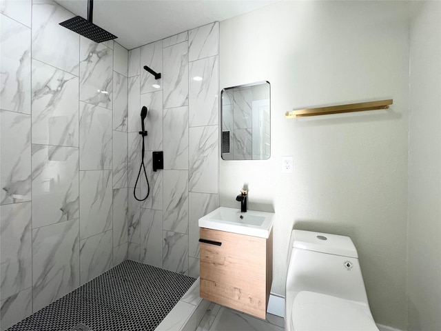 bathroom with vanity, toilet, and a tile shower