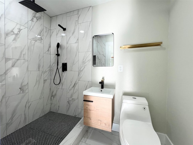 bathroom featuring a tile shower, vanity, and toilet