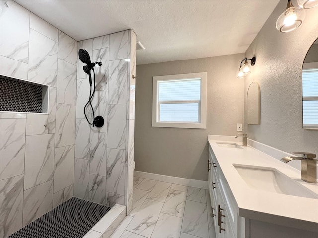 bathroom featuring tiled shower, a textured ceiling, vanity, and plenty of natural light